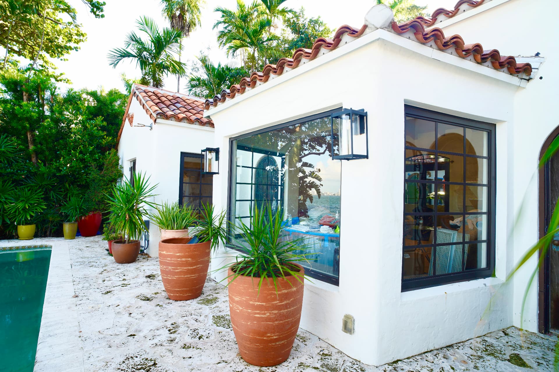 Renovated Miami home exterior with terracotta tile roof and tropical landscaping